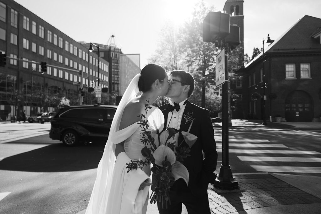bride and groom kiss in Central Square before their city wedding at PAGU
