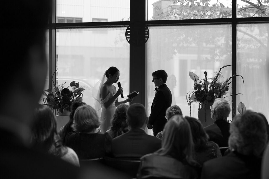 moody photo of bride and groom reciting wedding vows at PAGU wedding in Cambridge MA 