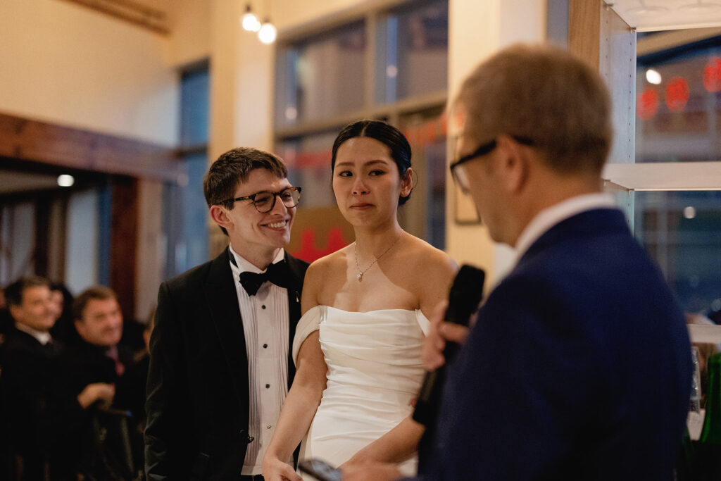 bride and groom emotional as father of the bride gives toast at their PAGU wedding