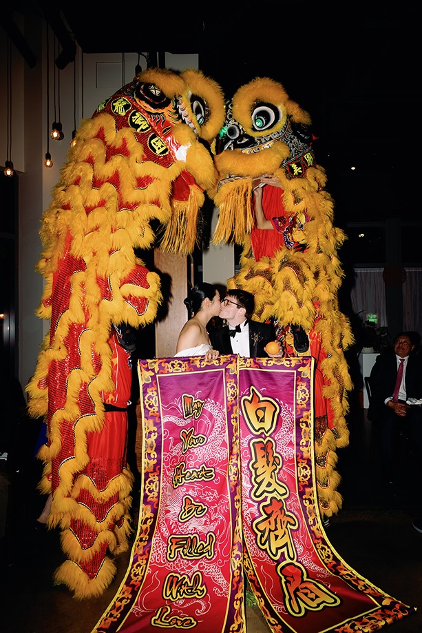 the bride and groom kissing under dragons at their boston restaurant wedding venues